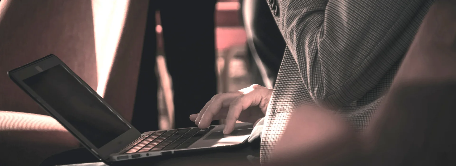 Broker working on a laptop in a warmly lit interior